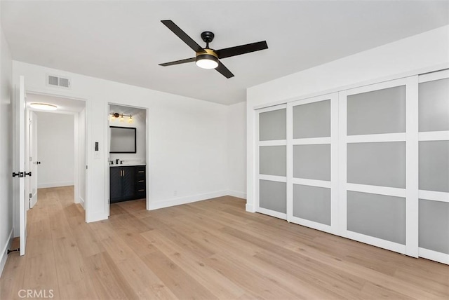 21692 Seaside Ln, Huntington Beach, CA 92646 - unfurnished bedroom featuring light wood-style floors, baseboards, ensuite bath, and a sink