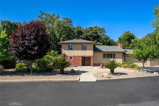 3580 Maricopa Rd, Atascadero, CA 93422 - split level home with a garage, a chimney, brick siding, concrete driveway, and roof with shingles
