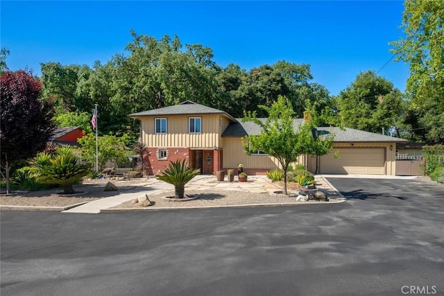 3580 Maricopa Rd, Atascadero, CA 93422 - view of front facade featuring driveway, a garage, brick siding, and view of wooded area