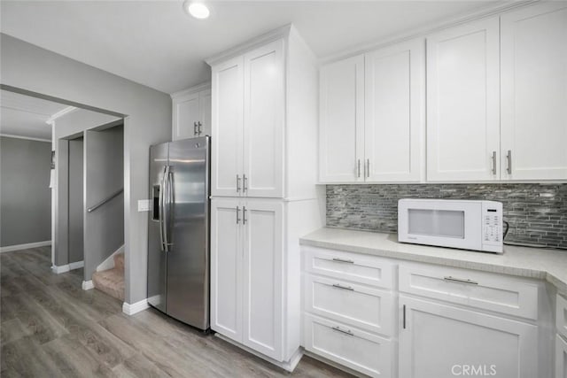 3580 Maricopa Rd, Atascadero, CA 93422 - kitchen with stainless steel fridge with ice dispenser, white microwave, light countertops, light wood-style floors, and backsplash