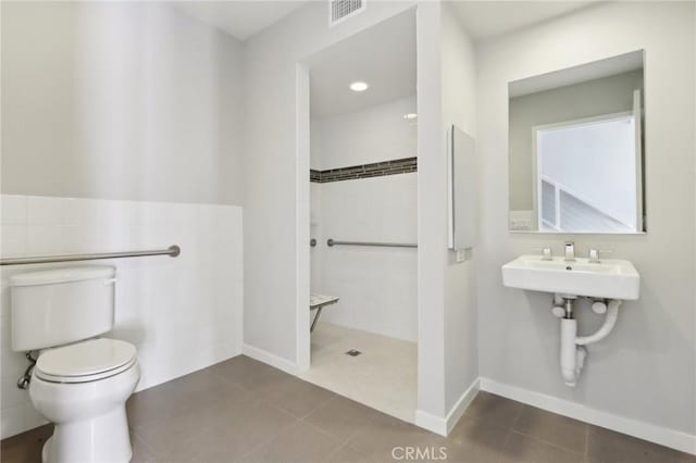 639 Channel Way, Costa Mesa, CA 92627 - full bath with a walk in shower, tile patterned flooring, tile walls, and a wainscoted wall