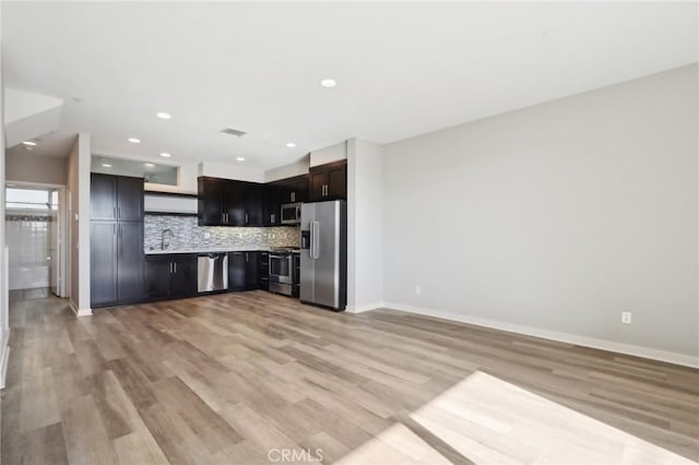 639 Channel Way, Costa Mesa, CA 92627 - kitchen with appliances with stainless steel finishes, tasteful backsplash, light wood finished floors, recessed lighting, and light countertops