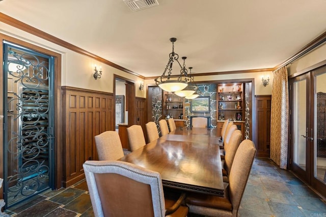 6937 Corte Langosta, Carlsbad, CA 92009 - dining space with stone tile floors, wainscoting, ornamental molding, french doors, and a decorative wall