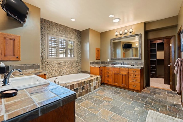 6937 Corte Langosta, Carlsbad, CA 92009 - full bath with two vanities, a bath, and stone tile flooring