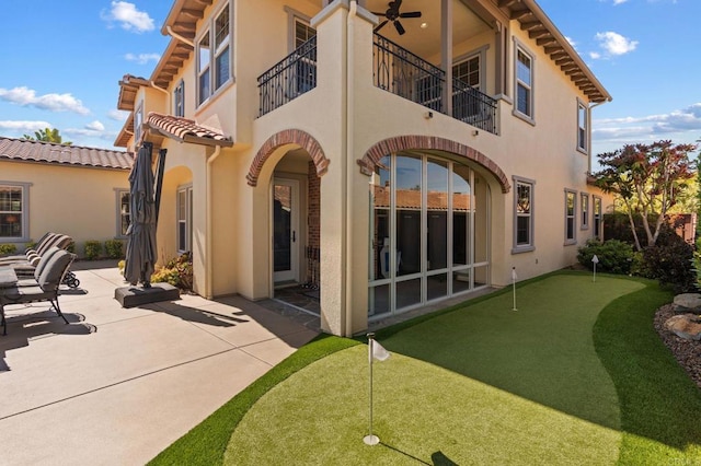6937 Corte Langosta, Carlsbad, CA 92009 - rear view of house featuring a putting area, stucco siding, a patio, a balcony, and a tile roof