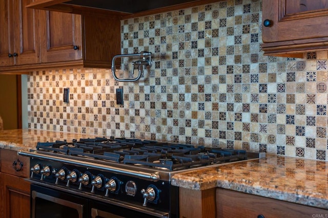 6937 Corte Langosta, Carlsbad, CA 92009 - kitchen featuring gas range, brown cabinetry, and tasteful backsplash