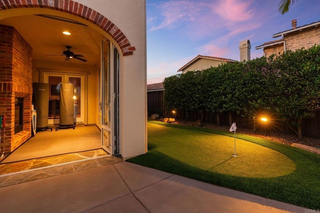 6937 Corte Langosta, Carlsbad, CA 92009 - exterior entry at dusk with ceiling fan, a patio, and stucco siding