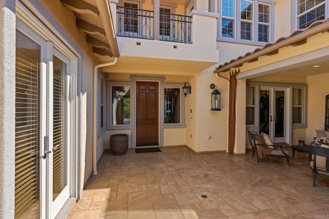 6937 Corte Langosta, Carlsbad, CA 92009 - entrance to property with french doors, a patio, stucco siding, and a balcony