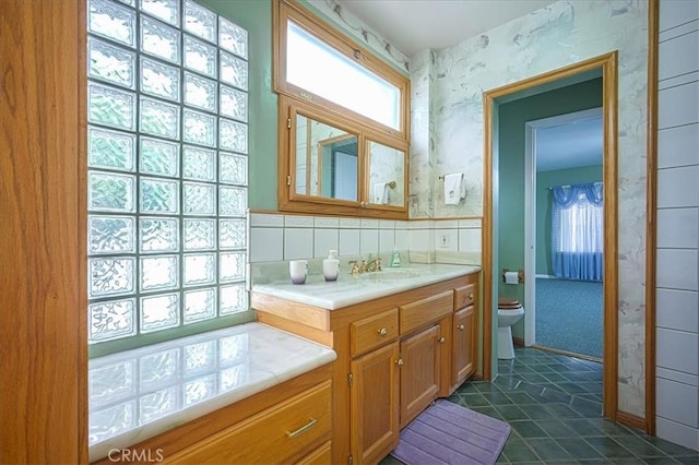 5062 Magnolia Ave, Riverside, CA 92506 - bathroom with vanity, wallpapered walls, toilet, and tile patterned flooring