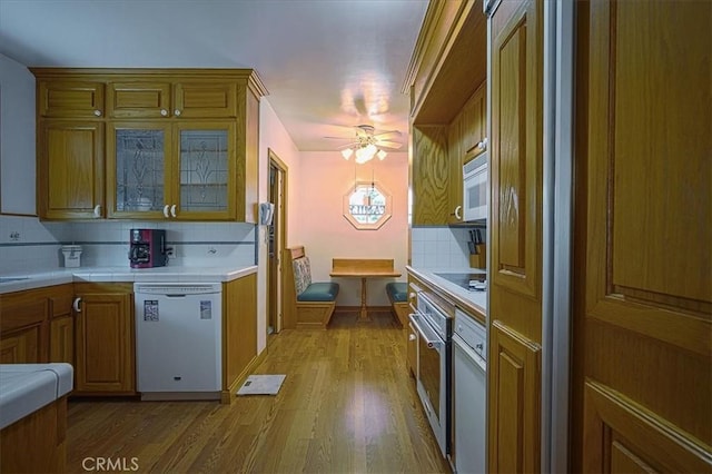 5062 Magnolia Ave, Riverside, CA 92506 - kitchen featuring white appliances, brown cabinets, tile countertops, light wood-type flooring, and tasteful backsplash