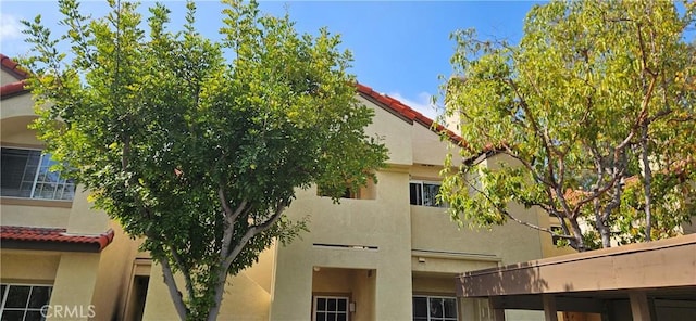 21208 Camelia Unit 44, Lake Forest, CA 92630 - view of side of home featuring stucco siding and a tiled roof