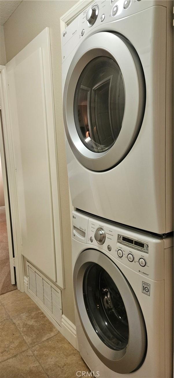 21208 Camelia Unit 44, Lake Forest, CA 92630 - washroom featuring stacked washer and clothes dryer and baseboards