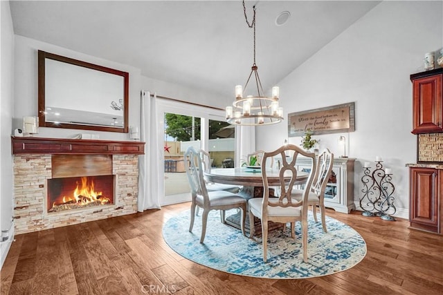 631 Holmes Ave, Placentia, CA 92870 - dining room featuring a chandelier, wood finished floors, a stone fireplace, baseboards, and high vaulted ceiling