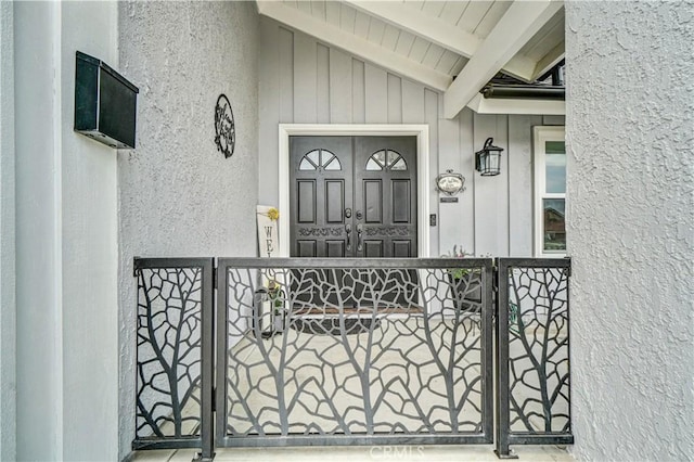631 Holmes Ave, Placentia, CA 92870 - view of exterior entry with board and batten siding, a porch, a gate, and stucco siding