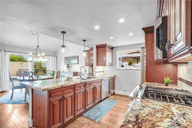 631 Holmes Ave, Placentia, CA 92870 - kitchen featuring a sink, stainless steel appliances, a peninsula, a textured ceiling, and vaulted ceiling