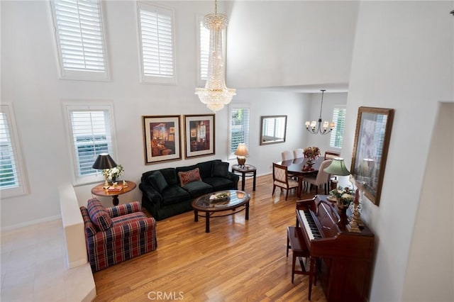 4583 Tuscani Dr, Cypress, CA 90630 - living area featuring a chandelier, a towering ceiling, healthy amount of natural light, light wood-style floors, and baseboards