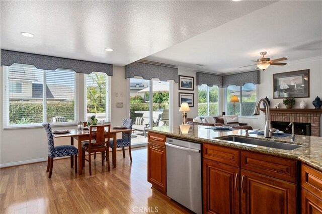 4583 Tuscani Dr, Cypress, CA 90630 - kitchen featuring stainless steel dishwasher, a sink, light wood-style flooring, ornamental molding, and open floor plan