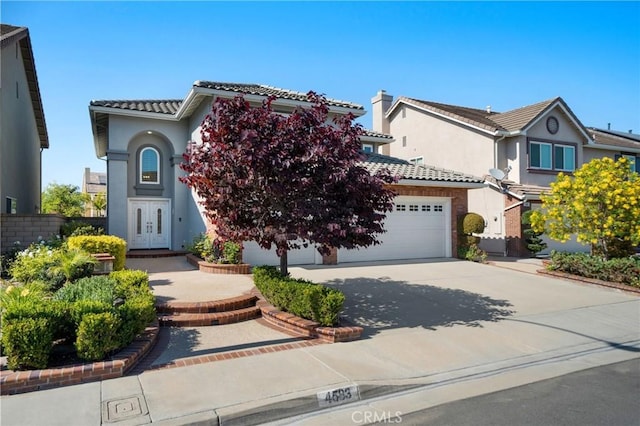 4583 Tuscani Dr, Cypress, CA 90630 - view of front of property featuring an attached garage, driveway, a tile roof, and stucco siding