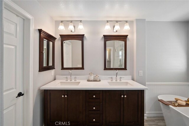 4583 Tuscani Dr, Cypress, CA 90630 - bathroom with a soaking tub, double vanity, wainscoting, and wood finished floors