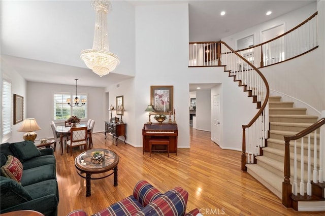 4583 Tuscani Dr, Cypress, CA 90630 - living room with a chandelier, light wood-style flooring, stairs, a high ceiling, and recessed lighting