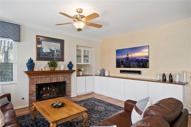 4583 Tuscani Dr, Cypress, CA 90630 - living area with wood finished floors, a ceiling fan, crown molding, a fireplace, and baseboards