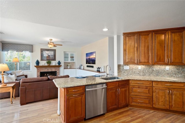 4583 Tuscani Dr, Cypress, CA 90630 - kitchen with dishwasher, a sink, brown cabinets, light wood finished floors, and a peninsula