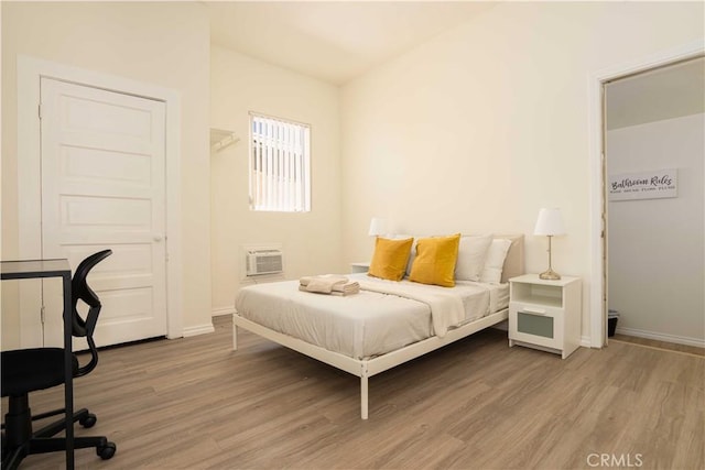 1168 W 35th St, Los Angeles, CA 90007 - bedroom featuring light wood-style flooring, baseboards, and a wall unit AC