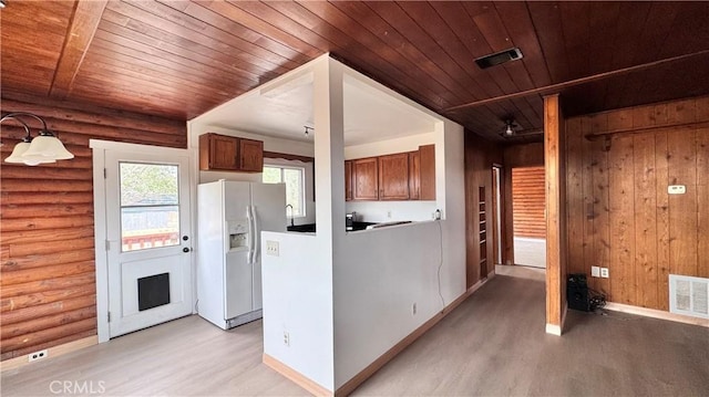 11213 Monte Vista Rd, Phelan, CA 92371 - kitchen with white fridge with ice dispenser, light wood finished floors, wooden ceiling, log walls, and brown cabinetry