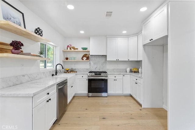 4312 Division St, Los Angeles, CA 90065 - kitchen featuring appliances with stainless steel finishes, open shelves, a sink, light wood finished floors, and light stone countertops