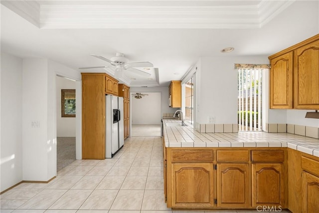 6459 E Via Arboles, Anaheim Hills, CA 92807 - kitchen featuring a tray ceiling, white fridge with ice dispenser, ornamental molding, ceiling fan, and brown cabinets