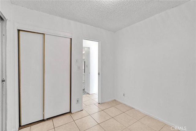 470 E Home St, Long Beach, CA 90805 - unfurnished bedroom featuring a textured ceiling, light tile patterned floors, a closet, and baseboards