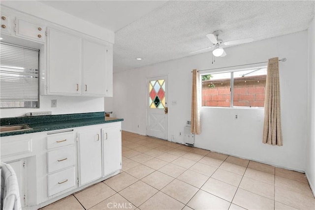 470 E Home St, Long Beach, CA 90805 - kitchen with dark countertops, ceiling fan, white cabinets, a textured ceiling, and light tile patterned flooring