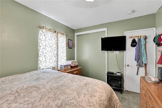 470 E Home St, Long Beach, CA 90805 - tiled bedroom with a wood stove, a textured ceiling, and a closet