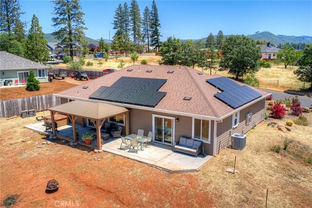 2381 Clearview Dr, Paradise, CA 95969 - back of property featuring a mountain view, roof mounted solar panels, a patio area, central AC unit, and a shingled roof