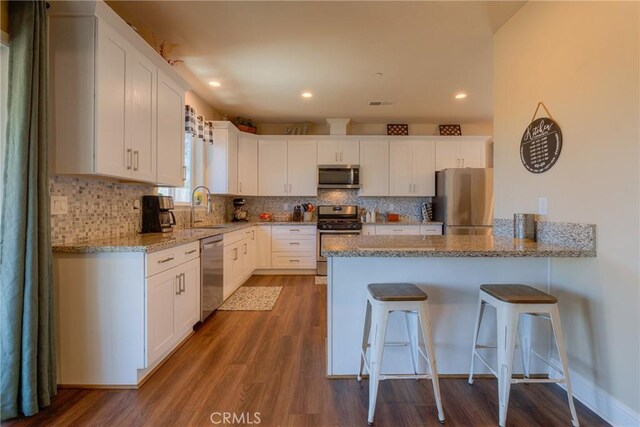 2381 Clearview Dr, Paradise, CA 95969 - kitchen with appliances with stainless steel finishes, a sink, a peninsula, white cabinets, and recessed lighting