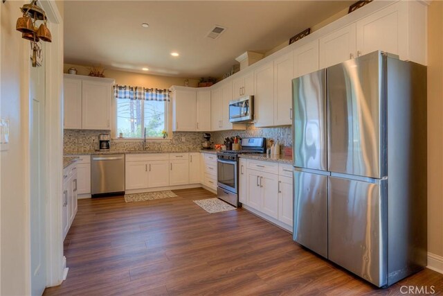 2381 Clearview Dr, Paradise, CA 95969 - kitchen with appliances with stainless steel finishes, recessed lighting, dark wood-style flooring, white cabinets, and decorative backsplash