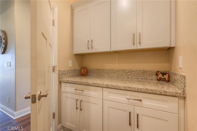 2381 Clearview Dr, Paradise, CA 95969 - kitchen featuring dark wood-style flooring, baseboards, white cabinets, and light stone counters