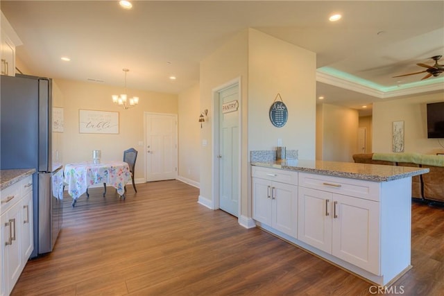 2381 Clearview Dr, Paradise, CA 95969 - kitchen with freestanding refrigerator, white cabinetry, a chandelier, open floor plan, and a peninsula