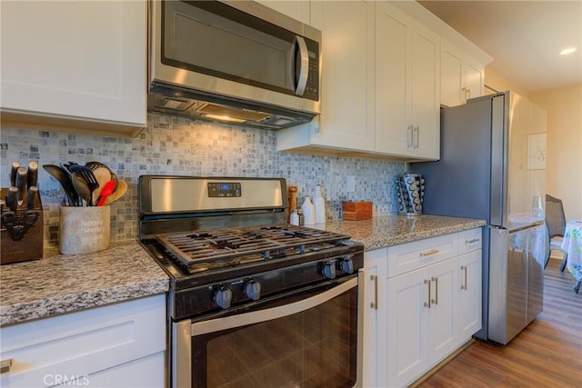 2381 Clearview Dr, Paradise, CA 95969 - kitchen featuring appliances with stainless steel finishes, white cabinets, tasteful backsplash, wood finished floors, and light stone countertops