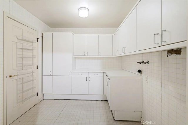 10724 Wilshire Blvd Unit 1010, Los Angeles, CA 90024 - laundry room featuring cabinet space, light tile patterned floors, and washer hookup
