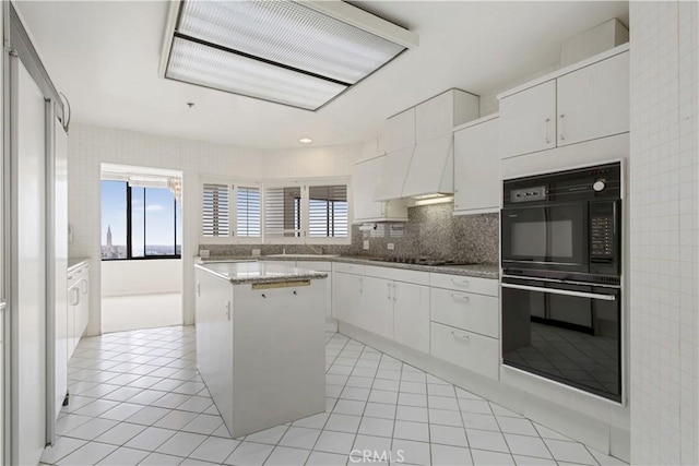 10724 Wilshire Blvd Unit 1010, Los Angeles, CA 90024 - kitchen featuring black appliances, a center island, white cabinets, decorative backsplash, and light tile patterned floors