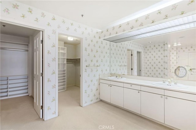 10724 Wilshire Blvd Unit 1010, Los Angeles, CA 90024 - full bathroom featuring double vanity, wallpapered walls, and a spacious closet