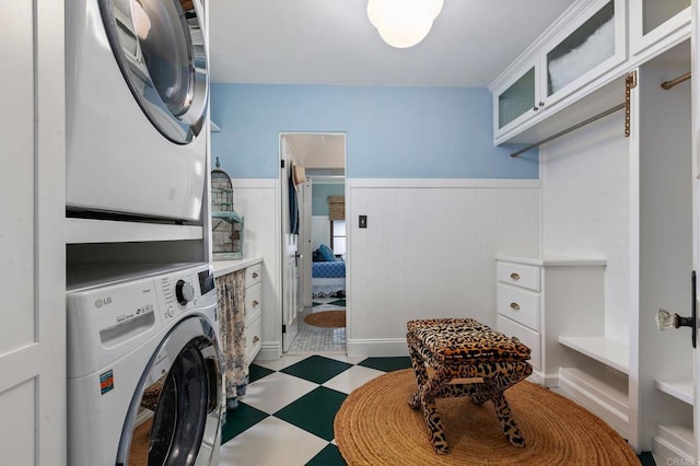 1008 S Ditmar St, Oceanside, CA 92054 - laundry room with stacked washer and clothes dryer, tile patterned floors, and a wainscoted wall