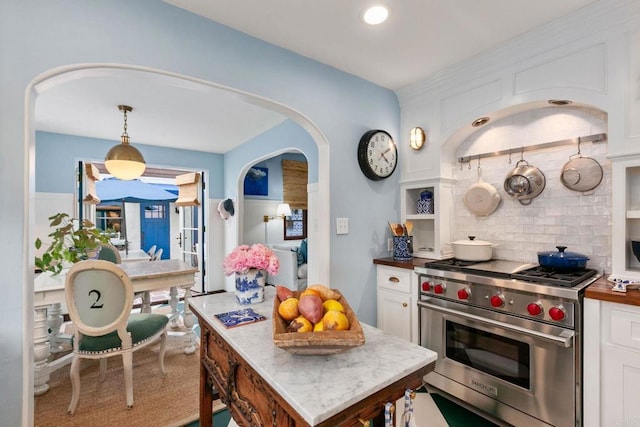 1008 S Ditmar St, Oceanside, CA 92054 - kitchen featuring luxury stove, white cabinetry, backsplash, arched walkways, and decorative light fixtures