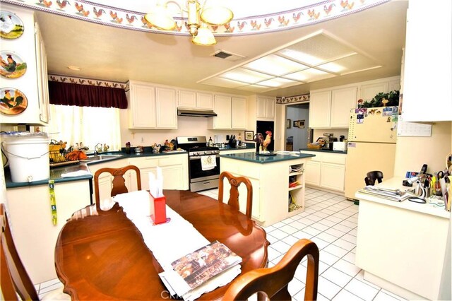 29058 Rosewood Ln, Highland, CA 92346 - kitchen with stainless steel gas stove, freestanding refrigerator, dark countertops, under cabinet range hood, and a kitchen island