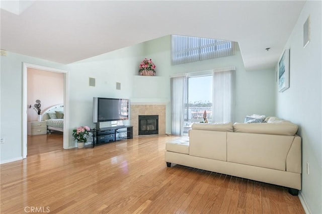 580 W Main St Unit 323, Alhambra, CA 91801 - living room featuring light wood-style flooring, a tiled fireplace, baseboards, and a high ceiling