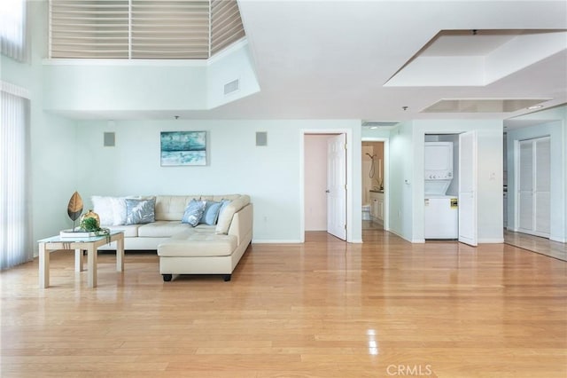 580 W Main St Unit 323, Alhambra, CA 91801 - living room with stacked washer / drying machine, light wood-style floors, and baseboards