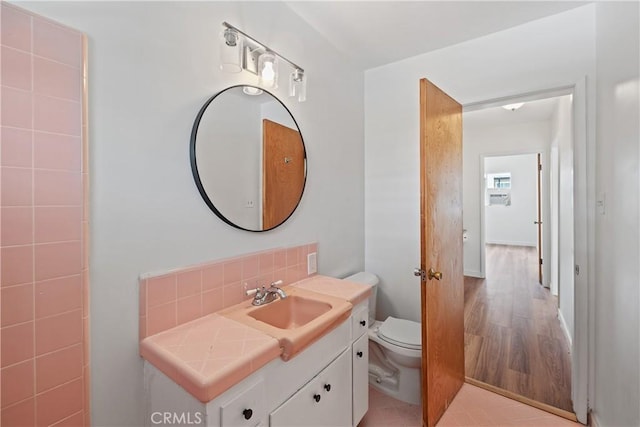 1273 E Appleton St Unit 4, Long Beach, CA 90802 - bathroom featuring toilet, vanity, decorative backsplash, and wood finished floors