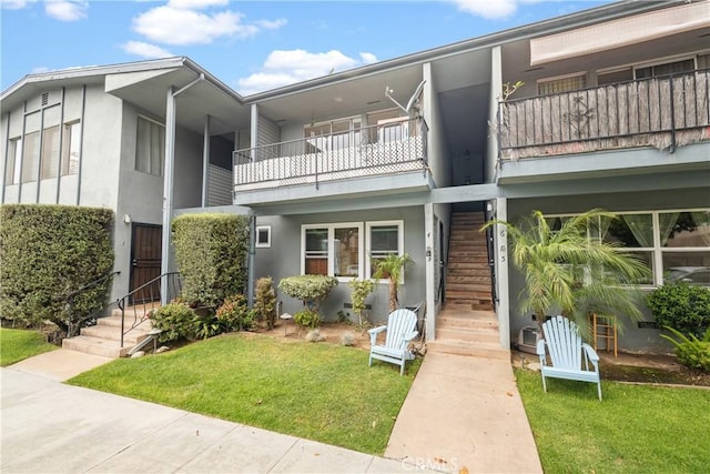 1273 E Appleton St Unit 4, Long Beach, CA 90802 - view of front of home featuring stucco siding, a balcony, stairway, and a front lawn