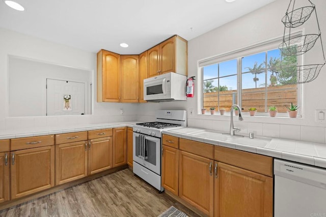 1125 Arcadia Rd, Encinitas, CA 92024 - kitchen with white appliances, light wood-style flooring, recessed lighting, and tile counters